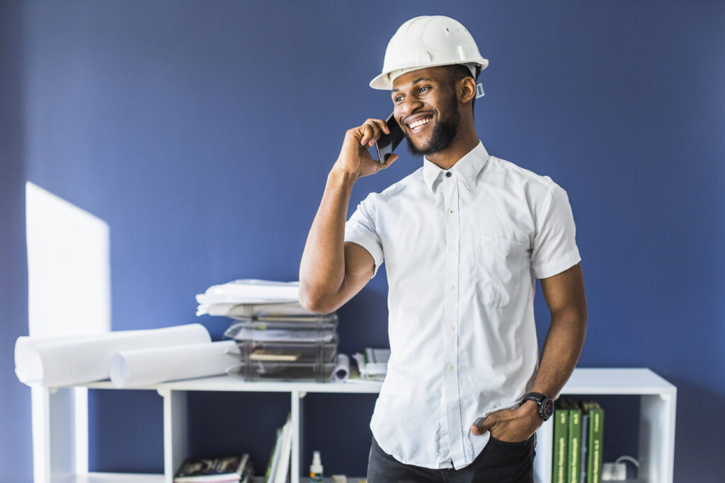 happy african american engineer talking mobile phone office